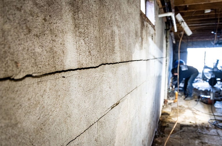 Large crack in basement wall indicating potential foundation damage.