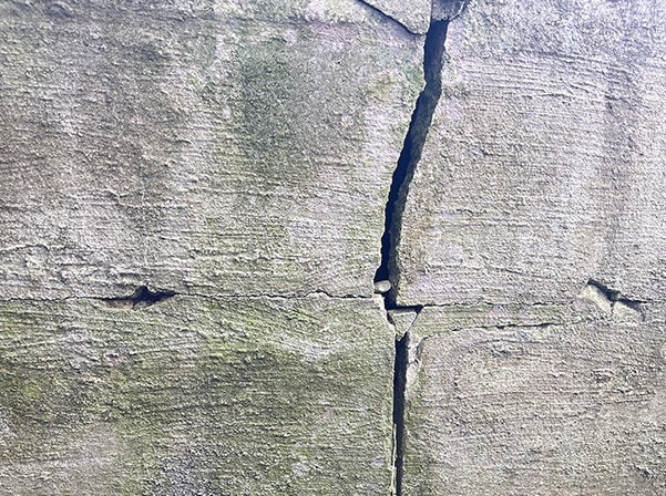 Large crack in foundation wall signaling potential structural problems and moisture damage.