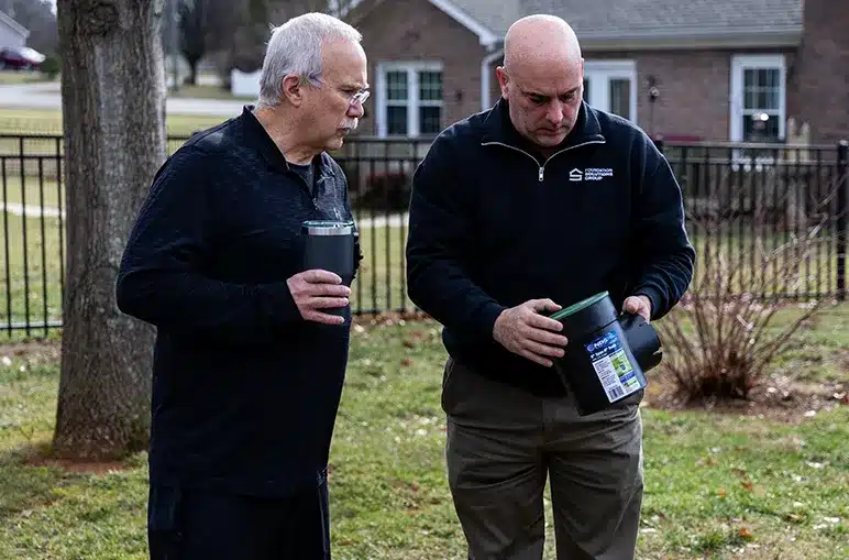 Homeowners and Foundation Solutions Group professional discussing foundation repair and soil moisture management.